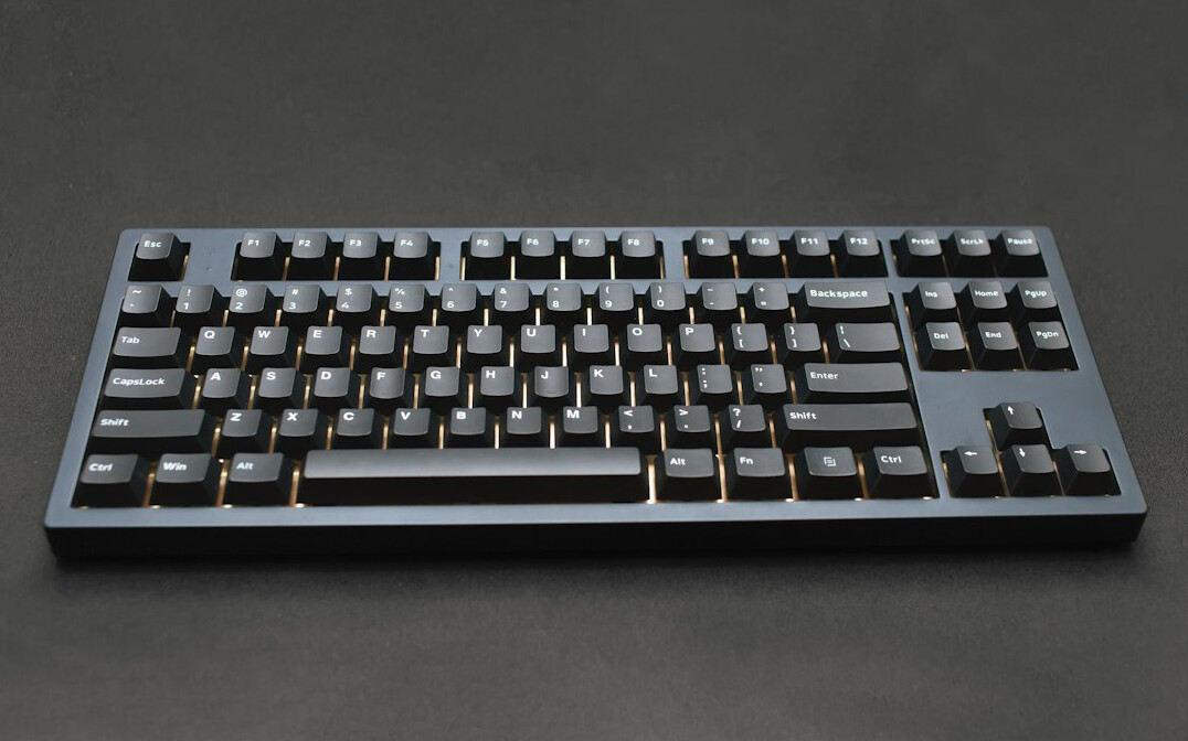 Hands typing on a laptop keyboard at a desk